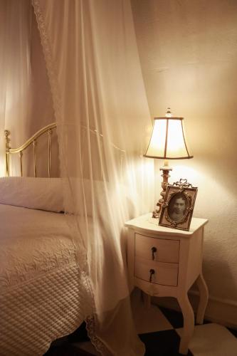 a bed with a picture on a table with a lamp at La Casa del General Hotel Boutique in Hidalgo del Parral