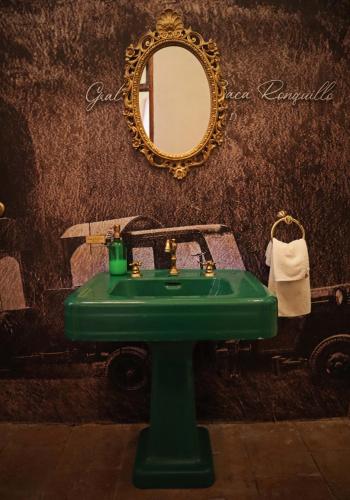 a green sink in a bathroom with a mirror at La Casa del General Hotel Boutique in Hidalgo del Parral
