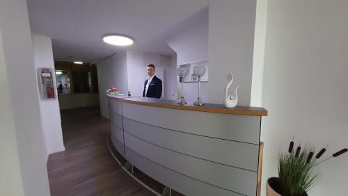 a man in a suit standing at a bar at Hotel Schneiderhof in Braunlage