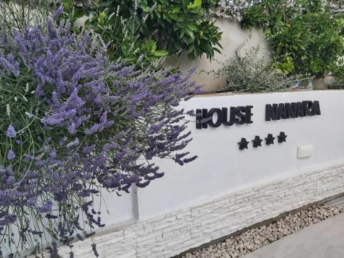 a sign for a house numaru with purple flowers at Apartment Nanara in Gustirna