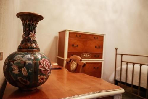 a vase sitting on a wooden table next to a dresser at La Casa del General Hotel Boutique in Hidalgo del Parral