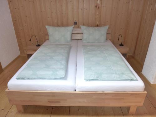 un par de camas en una habitación con paredes de madera en Ferienwohnung Hein, en Chieming