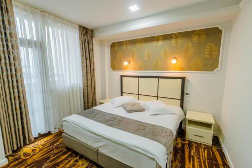 a bedroom with a bed and a large window at Hostel Parc in Fălticeni
