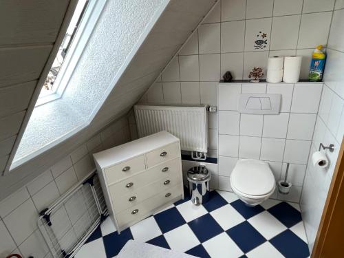 a small bathroom with a toilet and a checkered floor at FeWo HoLiDay HouSE Allgäu in Ottobeuren