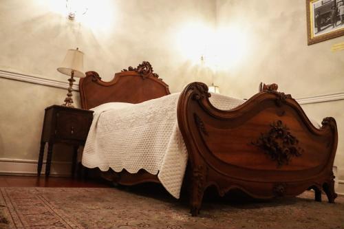 a bedroom with a wooden bed and a lamp at La Casa del General Hotel Boutique in Hidalgo del Parral