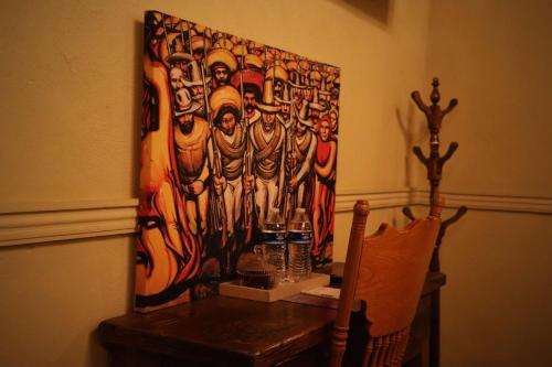 a painting hanging on a wall next to a wooden table at La Casa del General Hotel Boutique in Hidalgo del Parral