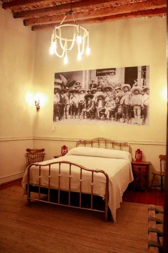 a bedroom with a bed and a picture on the wall at La Casa del General Hotel Boutique in Hidalgo del Parral