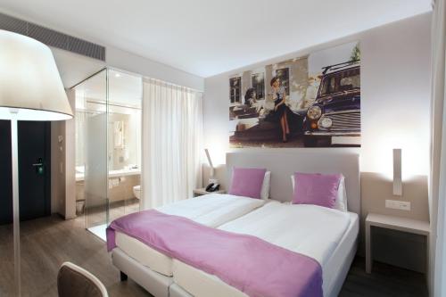 a bedroom with a large bed with purple sheets at Hotel City Lugano in Lugano