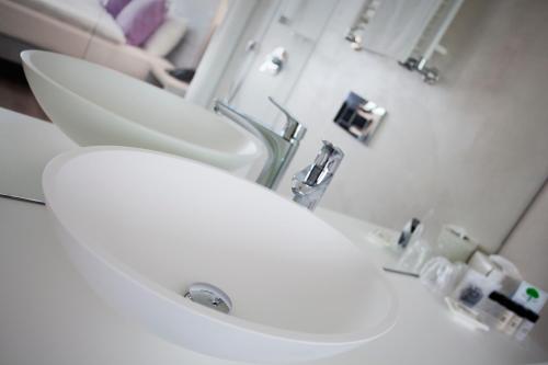 ein Badezimmer mit einem weißen Waschbecken und einem Spiegel in der Unterkunft Hotel City Lugano in Lugano