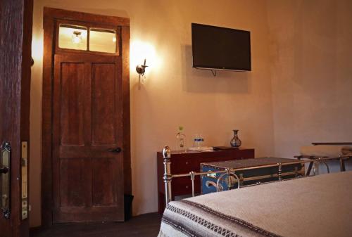 a bedroom with a bed and a television on the wall at La Casa del General Hotel Boutique in Hidalgo del Parral