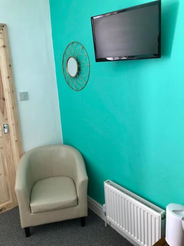a chair and a mirror on a blue wall at Yado Hotel in Blackpool