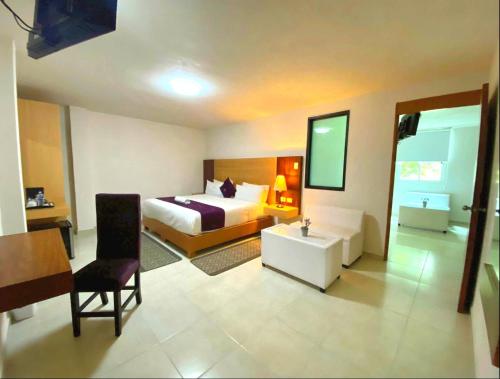 a bedroom with a bed and a desk and a chair at Hotel Posada Maria Sofia in Cholula