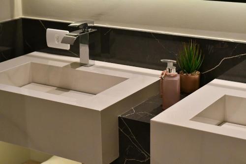 a bathroom with a sink and a faucet at Pousada Chão de Folhas SPA Boutique in Águas de Lindóia
