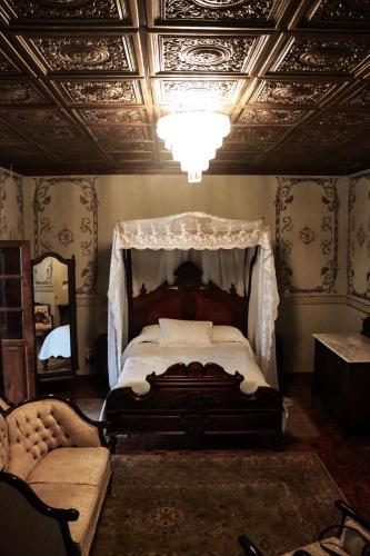 a bedroom with a canopy bed and a mirror at La Casa del General Hotel Boutique in Hidalgo del Parral