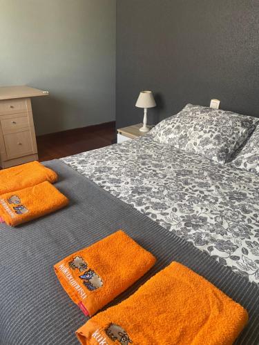 - une chambre avec un lit et des serviettes orange dans l'établissement Amezola 2- Habitación con baño exterior de uso privado en casa compartida, à Bilbao
