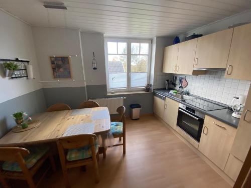 eine Küche mit einem Holztisch und einem Esszimmer in der Unterkunft Ferienwohnung Schröder - 2347 in Bünsdorf