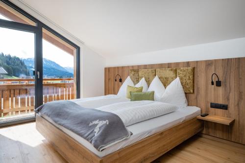 a bedroom with a large bed with a large window at My Dahoam in Eben im Pongau