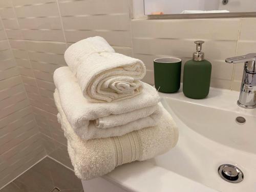 a pile of towels sitting on top of a sink at BELVEDERE Apartments in Bucharest