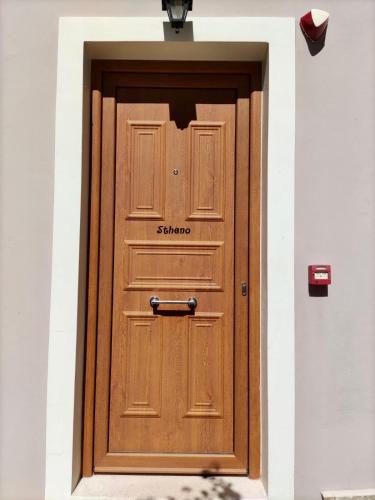 a wooden door in a building with a light above it at Villa Semipuella in Agios Nikitas