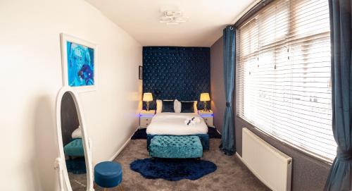 ein Schlafzimmer mit einem Bett, einem Stuhl und einem Fenster in der Unterkunft Cosy Luxury Suite Jewellery Quarter - Birmingham in Birmingham