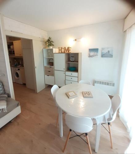 a white dining room with a table and chairs at STUDIO HYERES PORT in Hyères