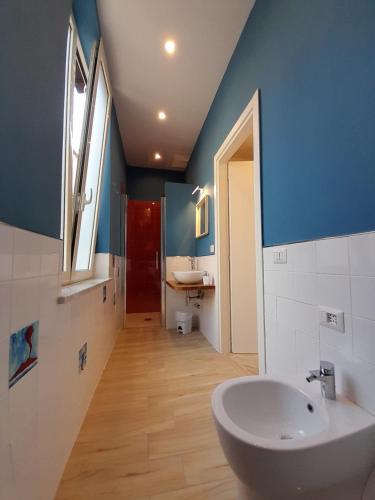 een badkamer met een witte wastafel en een blauwe muur bij Casa Sciò in Sorrento