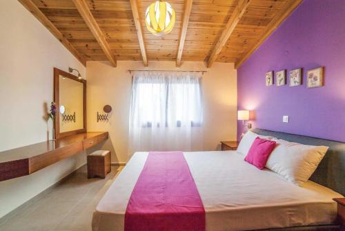 プラタニアスにあるPortokalia Platanias Creteの紫の壁のベッドルーム1室(大型ベッド1台付)