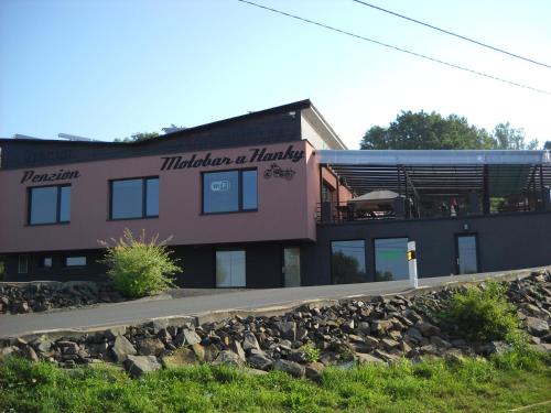 a building with a bunch of rocks in front of it at Penzion a Motobar Bravantice in Bravantice