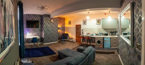 ein Wohnzimmer mit einem Sofa und einer Küche in der Unterkunft Cosy Luxury Suite Jewellery Quarter - Birmingham in Birmingham