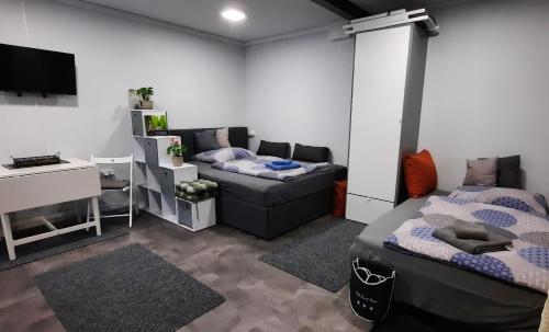 Habitación con 2 camas, escritorio y escritorio. en Gemütliches Tiny Home mit 30m2 inklusive Kochmöglichkeit, en Lenzing