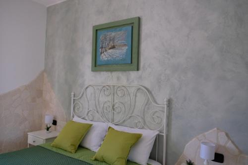 a bedroom with a bed with green and white pillows at B&B VILLA IOLANDA un soggiorno in Relax vista Mare e Montagna in Fossacesia