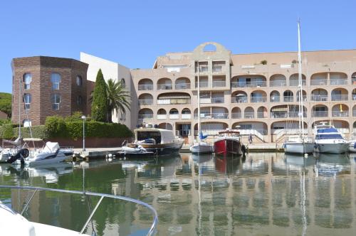 a marina with boats docked in front of a building at STUDIO HYERES PORT in Hyères