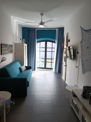 a living room with a blue couch and a window at savonaamare 2.0 in Savona