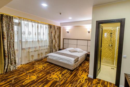 a bedroom with a bed and a large window at Hostel Parc in Fălticeni