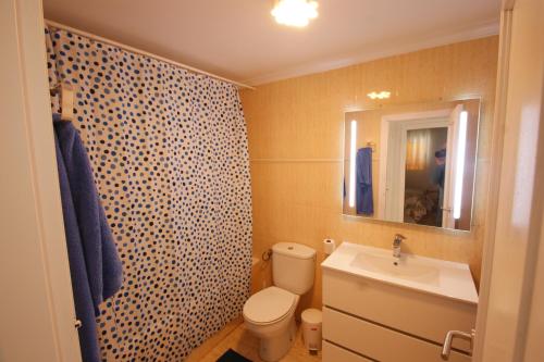 een badkamer met een toilet, een wastafel en een spiegel bij Apartamento con terraza y piscina a 300m de playa in Vera