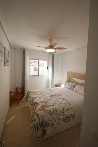 een slaapkamer met een bed en een plafondventilator bij Apartamento con terraza y piscina a 300m de playa in Vera