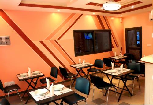 - un restaurant avec des tables et des chaises dans une salle dans l'établissement HOTEL LAVAL, à Abidjan