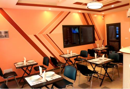 a restaurant with tables and chairs in a room at HOTEL LAVAL in Abidjan