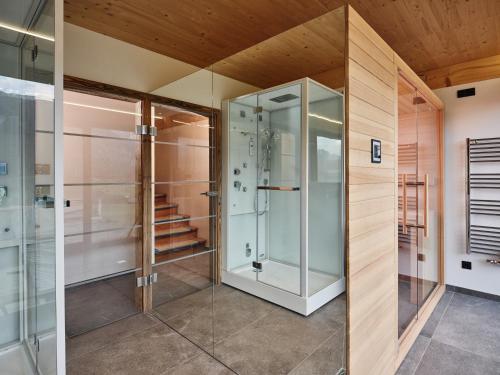a walk in shower in a bathroom with glass doors at Bergresort Hauser Kaibling by ALPS RESORTS in Haus im Ennstal