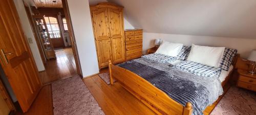 a bedroom with a wooden bed with two pillows at Patkóház in Keszthely