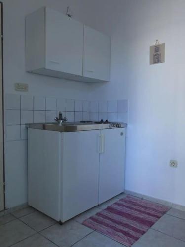 a white kitchen with a sink and a counter at Apartments Biba & Lucy in Ražanac