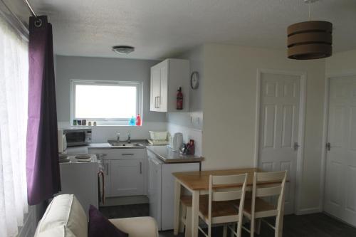 a small kitchen with a table and a table and chairs at 78 Florida Holiday Park in Hemsby