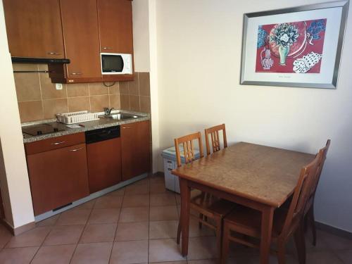 cocina con mesa de madera, mesa y sillas en Aparthotel Rosa - apartma 204, en Podčetrtek