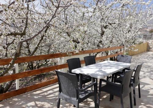 a table and chairs on a patio with flowering trees at Oriental Nature in Majdal Shams
