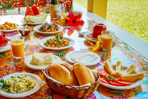 uma mesa com pratos de comida e copos de sumo de laranja em Ganga Zumba Pousada & Hostel em Barra Grande