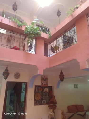 a building with balconies and potted plants at Riad dar Ahlam in Aït Baha