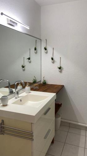 La salle de bains est pourvue d'un lavabo et d'un miroir. dans l'établissement Location appartement F2 à Caen My precious Home F2 à Caen, à Caen