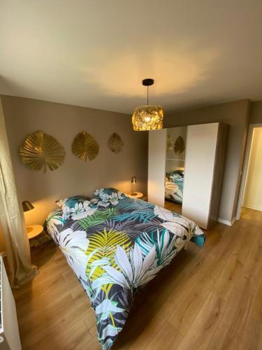 een slaapkamer met een bed met een kleurrijk dekbed bij Location appartement F2 à Caen My precious Home F2 à Caen in Caen