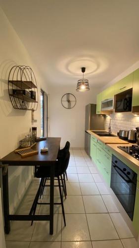 a kitchen with green cabinets and a wooden table at Location appartement F2 à Caen My precious Home F2 à Caen in Caen