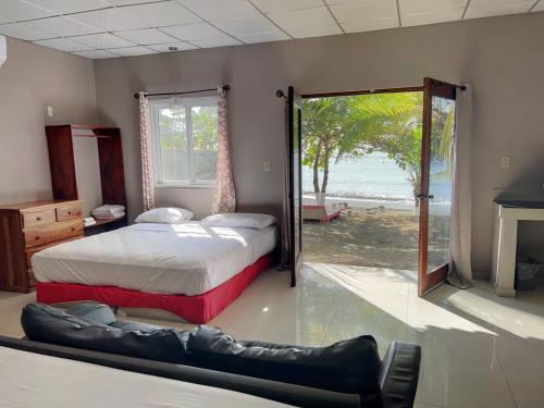 a bedroom with two beds and a sliding glass door at Big Daddy's Beach Club & Hotel in Puerto Armuelles